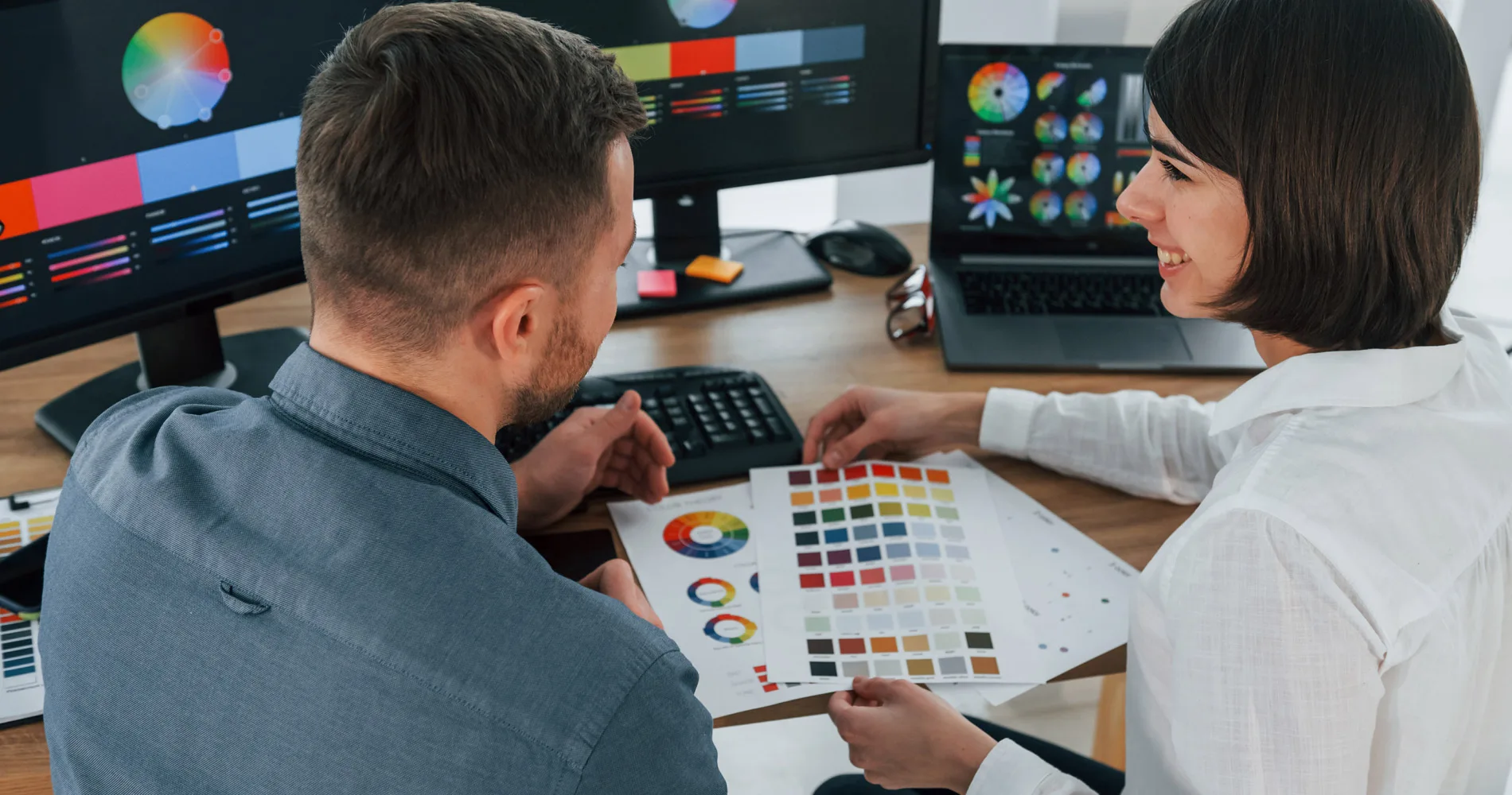 Top view. Two Graphic designers working together in the office looking at colour palettes